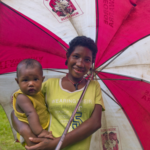 Mother and child under an umbrella, Milne Bay Province, Trobriand Island, Papua New Guinea