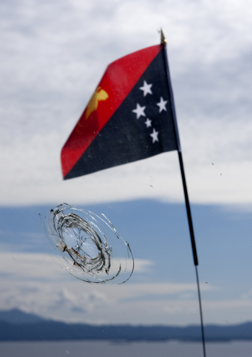 Flag in front of a bullet hole, East New Britain Province, Rabaul, Papua New Guinea