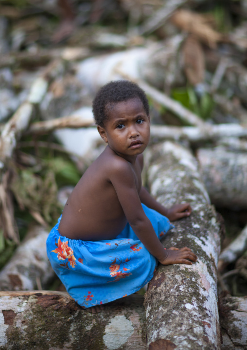 Girl sit on tree trunks, Milne Bay Province, Alotau, Papua New Guinea