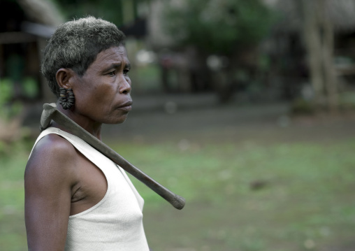 Woman with an axe on the shoulder, Milne Bay Province, Trobriand Island, Papua New Guinea