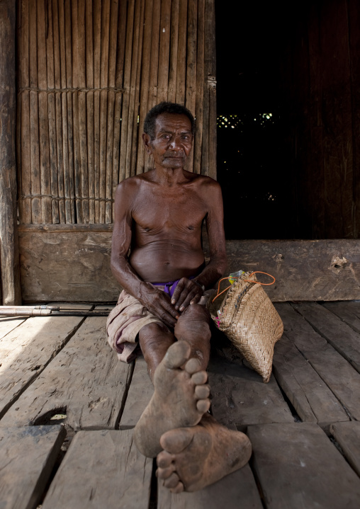 Old man in front of his house, Milne Bay Province, Trobriand Island, Papua New Guinea