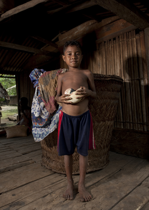 Boy in front of a giant basket, Milne Bay Province, Trobriand Island, Papua New Guinea