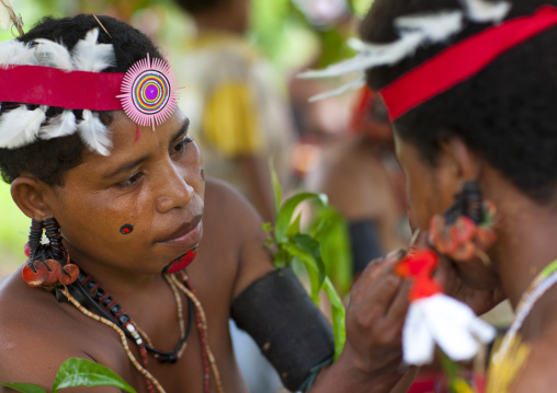 Tribal women makeup before a ceremony, Milne Bay Province, Trobriand Island, Papua New Guinea