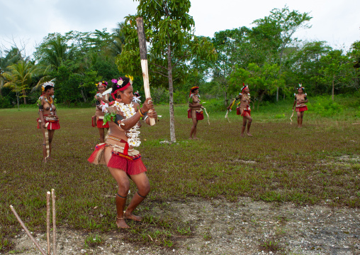 Girls in traditional clothing playing cricket, Milne Bay Province, Trobriand Island, Papua New Guinea
