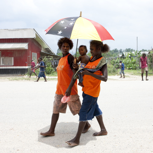 Women at buka market walking under an umbrella, Autonomous Region of Bougainville, Bougainville, Papua New Guinea