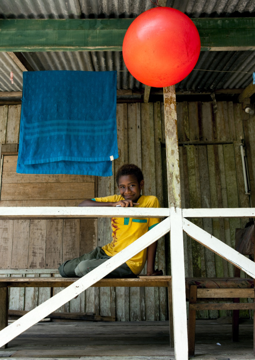 Boy sit on a balcony, New Ireland Province, Laraibina, Papua New Guinea