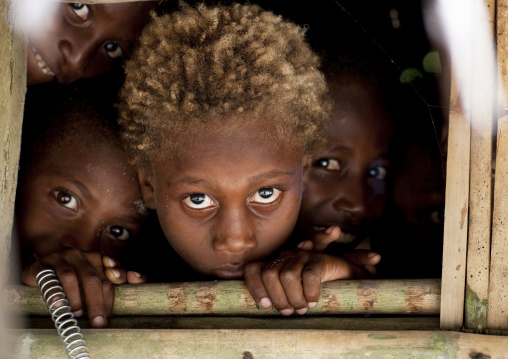 Children with blonde hair looking thru a window, New Ireland Province, Kapleman, Papua New Guinea