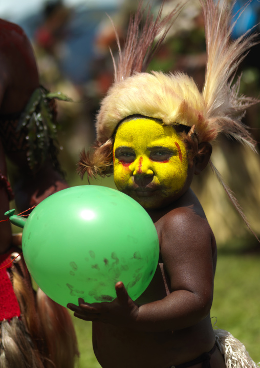 Portrait of a Huli tribe boy with a baloon during a sing-sing, Western Highlands Province, Mount Hagen, Papua New Guinea
