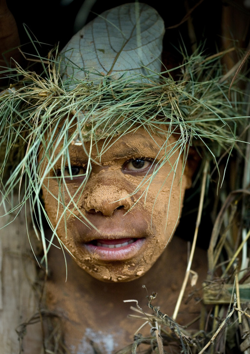 Chimbu tribe boy with a vegetal headwear during a Sing-sing ceremony, Western Highlands Province, Mount Hagen, Papua New Guinea