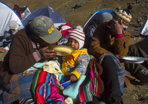 Peruvian Parents Feeding Their Baby During The Qoyllur Riti Festival, Ocongate Cuzco, Peru