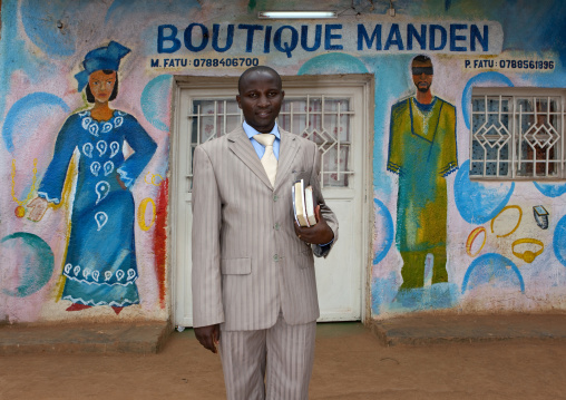 Rwandan man in front of a tailor shop mural, Kigali Province, Kigali, Rwanda