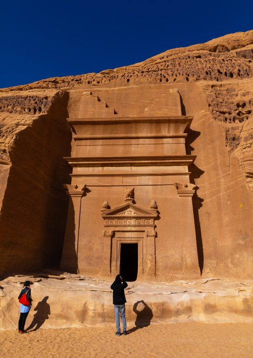 Tourists in front of a nabataean tomb in al-Hijr archaeological site in Madain Saleh, Al Madinah Province, Alula, Saudi Arabia
