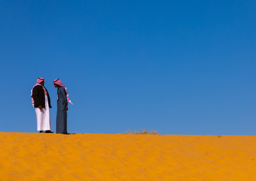 Saudi men on a sand dune, Al Madinah Province, Alula, Saudi Arabia