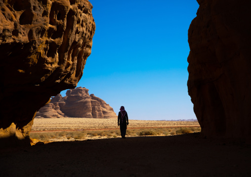 Sausi man walking in the middle of the mountains of wadi al gura, Al Madinah Province, Alula, Saudi Arabia