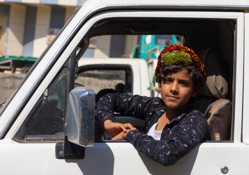 Portrait of a flower boy wearing a floral crown on the head and driving a car, Jizan province, Addayer, Saudi Arabia