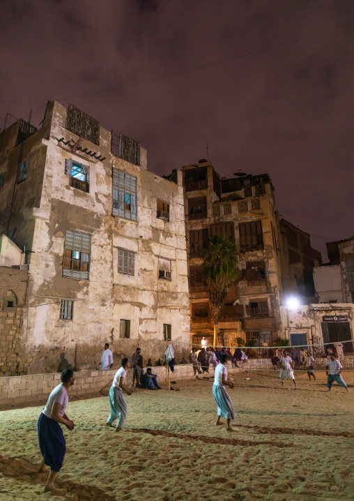 Men playing volley ball in front of old houses with mashrabiyas in al-Balad quarter, Mecca province, Jeddah, Saudi Arabia