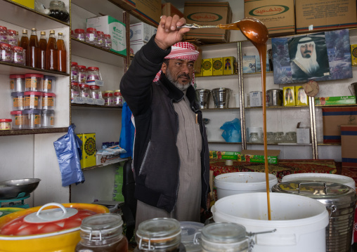 Saudi man selling honey in a shop, Asir province, Abha, Saudi Arabia