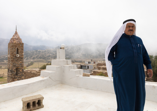 Saudi man in front of a mosque made of stones, Asir province, Tanomah, Saudi Arabia