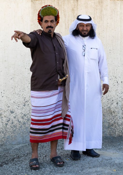 Portrait of a flower man wearing floral crowns on the head with a friend in traditional saudi clothing, Jizan Province, Addayer, Saudi Arabia