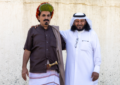 Portrait of a flower man wearing floral crowns on the head with a friend in traditional saudi clothing, Jizan Province, Addayer, Saudi Arabia