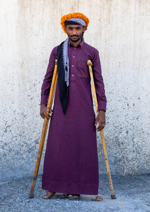 Portrait of a yemeni refugee with crutches wearing a floral crown on the head, Jizan Province, Addayer, Saudi Arabia