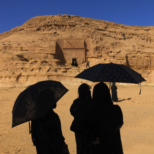 Tourists with umbrellas in madain saleh archaeologic site, Al Madinah Province, Alula, Saudi Arabia
