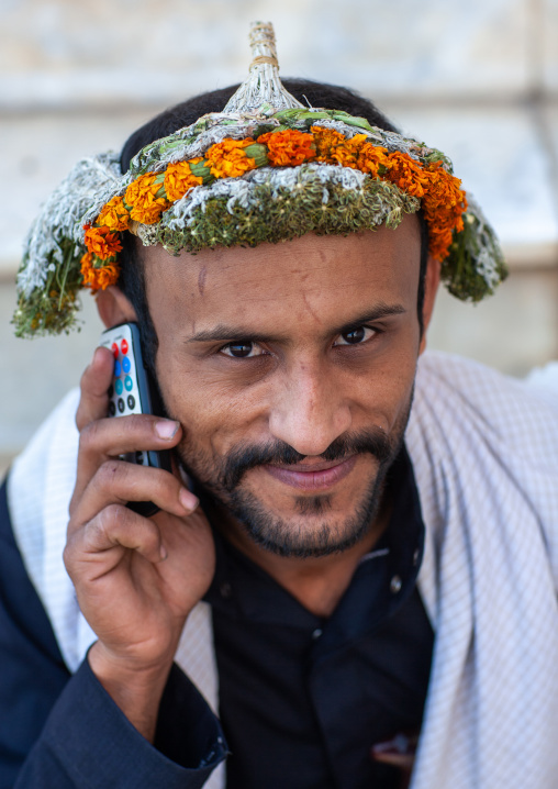 Portrait of an asiri flower man calling with his mobile phone, Asir province, Al Farsha, Saudi Arabia