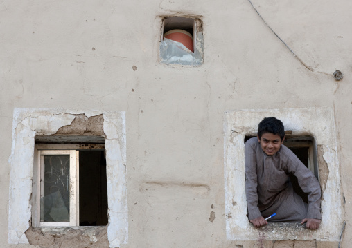 Saudi boy in a window in the old town, Najran Province, Najran, Saudi Arabia