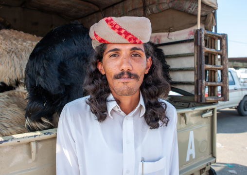 Portrait of a saudi man with long hair in a sheep market, Najran Province, Najran, Saudi Arabia