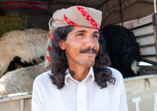 Portrait of a saudi man with long hair in a sheep market, Najran Province, Najran, Saudi Arabia