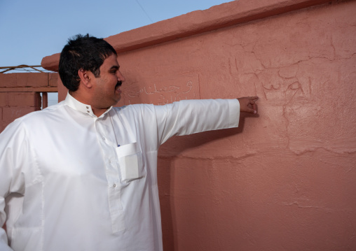 Saudi man showing a detail of his house, Asir Province, Aseer, Saudi Arabia