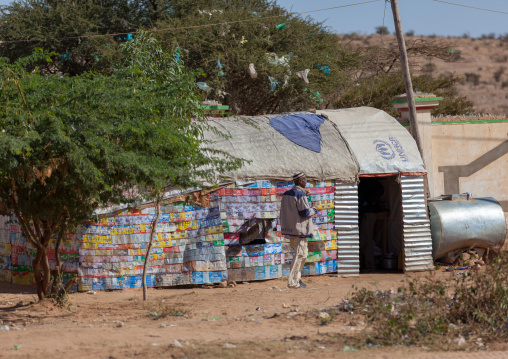Somali man in front of a slum hut made of corrugated iron and canvas, Woqooyi Galbeed region, Hargeisa, Somaliland