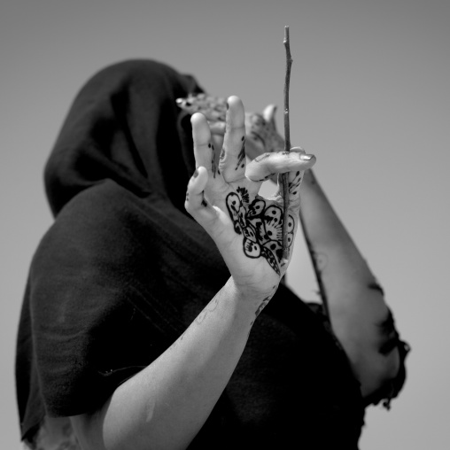 A Woman With Henna Tattoo Holding A Stick Is Hiding Away From The Camera, Berbera Area, Somaliland