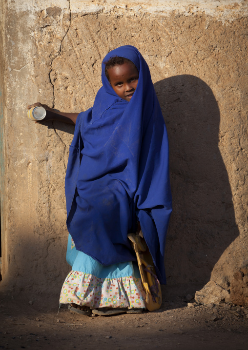 Little Girl Wearing A Blue Veil And Holding A Juice Can Leaning Against A Wall, Baligubadle, Somaliland