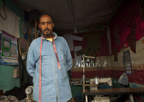 A Tailor Wearing A Blue Shirt And Tape Measure On His Neck In His Workshop, Boorama, Somaliland