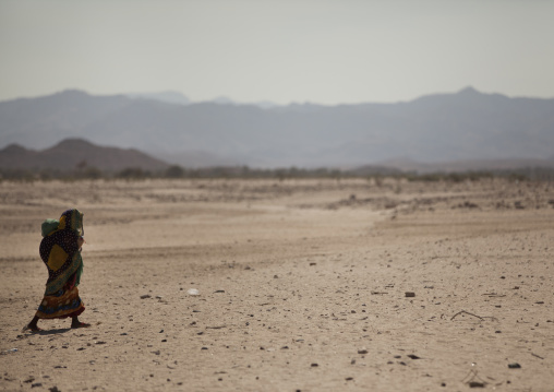A Woman Is Walking In A Desert Rocky Place With  Mountains In The Background, Hargeisa, Somaliland