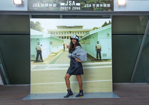 Tourist posing in front of a giant picture of the DMZ border, North Hwanghae Province, Panmunjom, South Korea