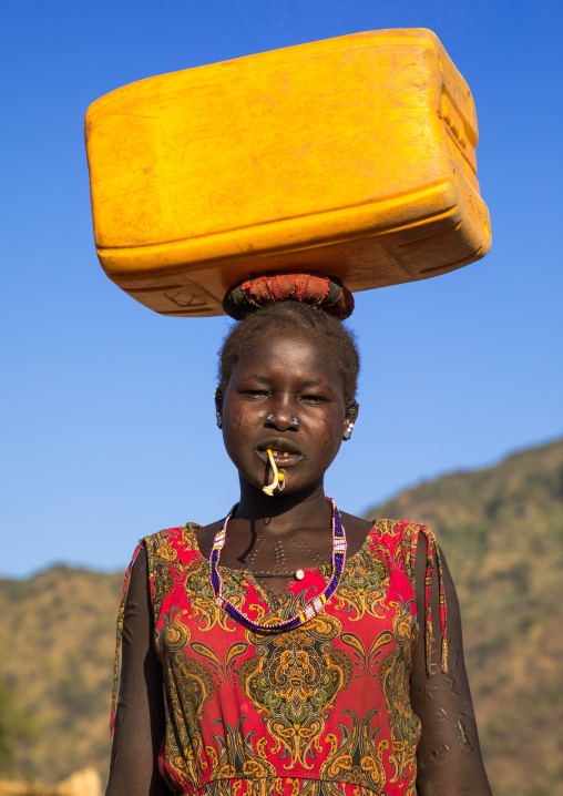 Portrait of a Larim tribe woman carrying a jerrycan of water on the head, Boya Mountains, Imatong, South Sudan