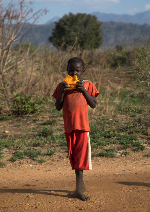 Larim tribe boy eating doum palm fruit, Boya Mountains, Imatong, South Sudan