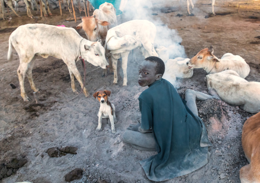 Mundari tribe boy making a campfire made with dried cow dungs to repel flies and mosquitoes, Central Equatoria, Terekeka, South Sudan