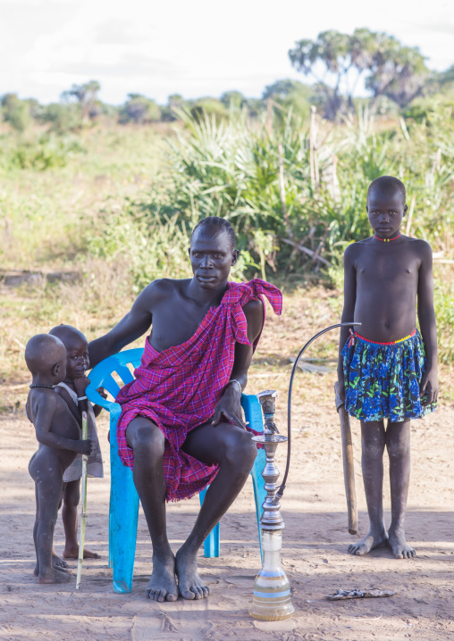 Mundari tribe father with his children smoking shisha, Central Equatoria, Terekeka, South Sudan