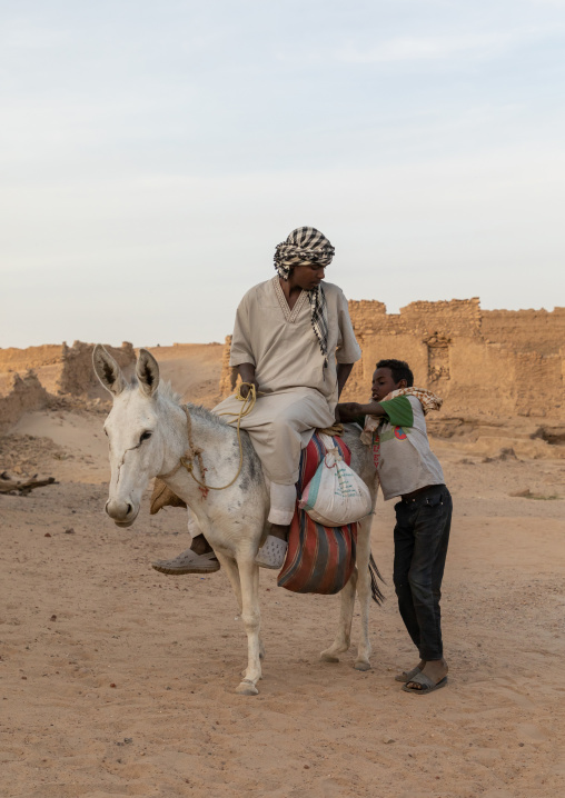 Sudanese men riding a donkey, Northern State, Al-Khandaq, Sudan
