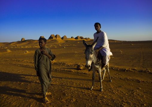 Sudan, Kush, Meroe, kids in front of the pyramids and tombs in royal cemetery