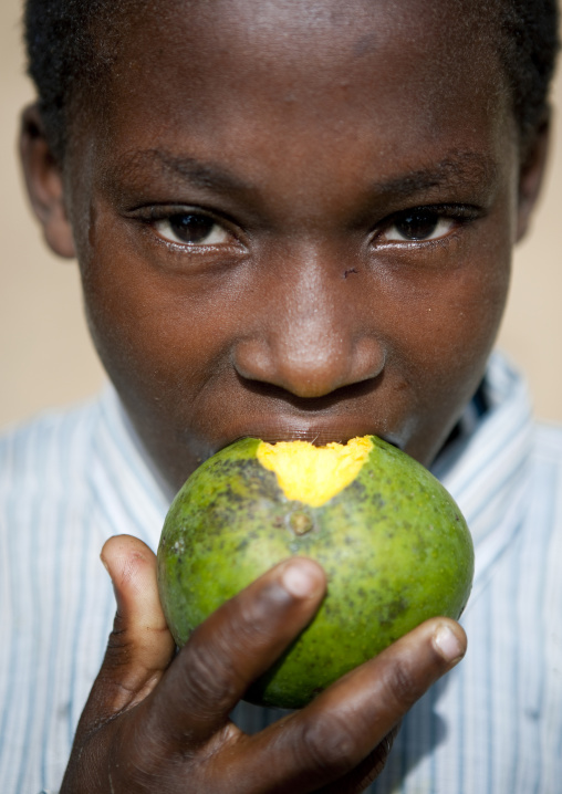 Kid eating mango, Pemba, Tanzania