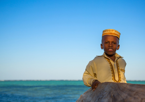 Tanzania, Zanzibar, Kizimkazi, young muslim boy in school uniform on beach
