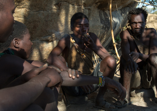Tanzania, Serengeti Plateau, Lake Eyasi, hadzabe tribe men smoking cannabis