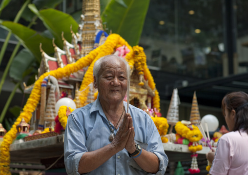 Man in a temple in the street, Bangkok, Thailand