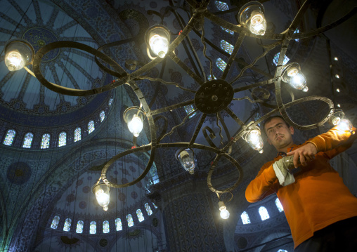 Man changing the lamps inside the Blue mosque sultan Ahmet Camii, Sultanahmet, istanbul, Turkey