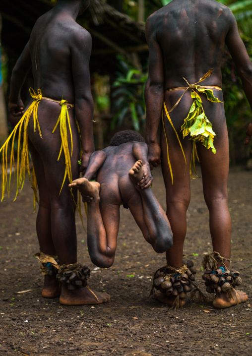 Small Nambas tribesmen demonstrating with a child a traditional stretcher made from leaves, Malekula island, Gortiengser, Vanuatu