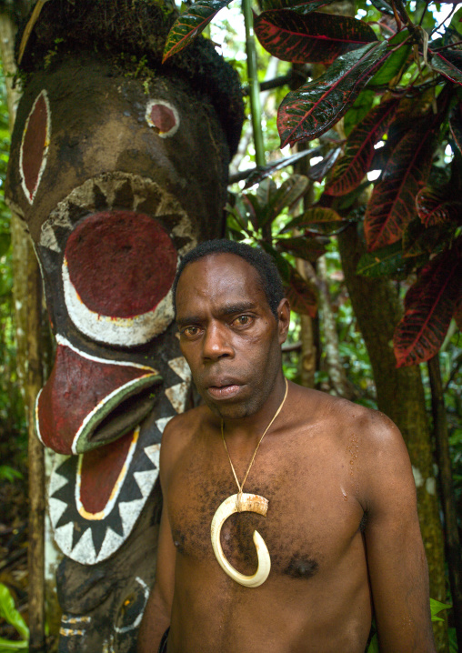 Portrait of chieftain Sekor in front of a painted grade statue, Ambrym island, Olal, Vanuatu